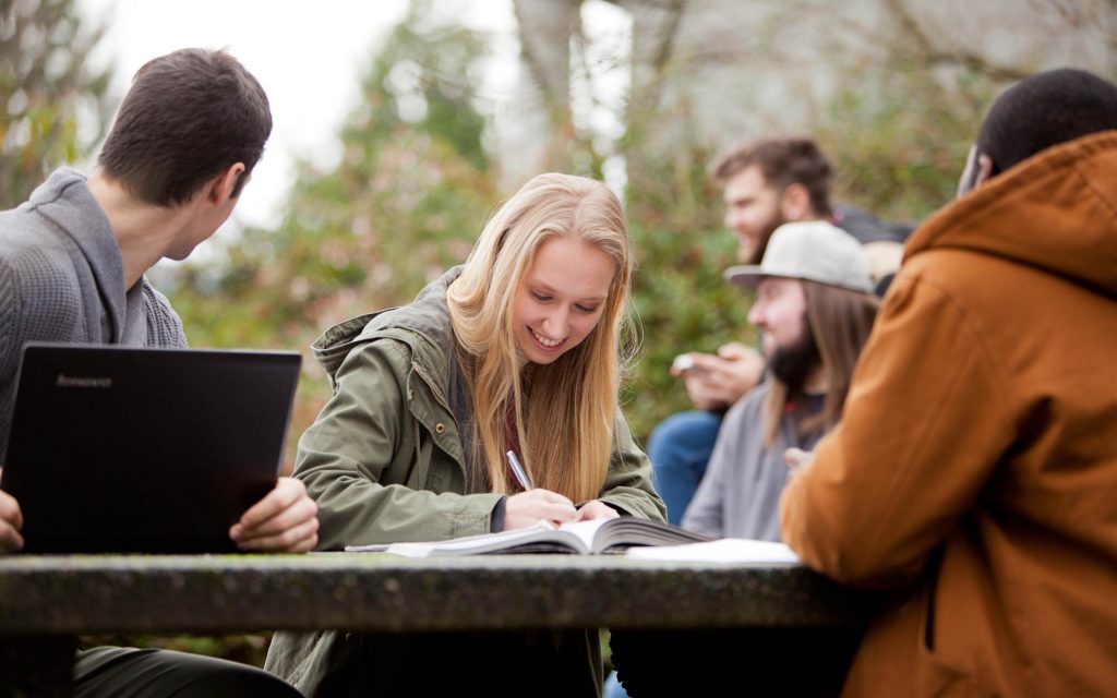 A group of people looking at a laptop